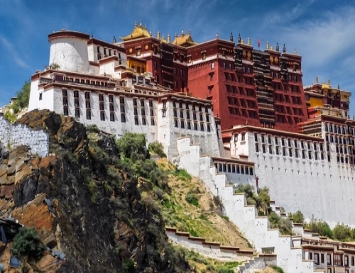 Panoramic view of Potala Palace in Lhasa, Tibet with its iconic white and red structure on a hill under a clear blue sky