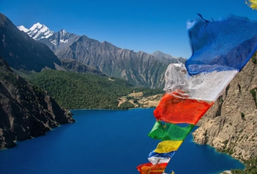 Shey Phoksundo Lake in Lower Dolpo with turquoise water, cliffs, and Ringmo village in the background