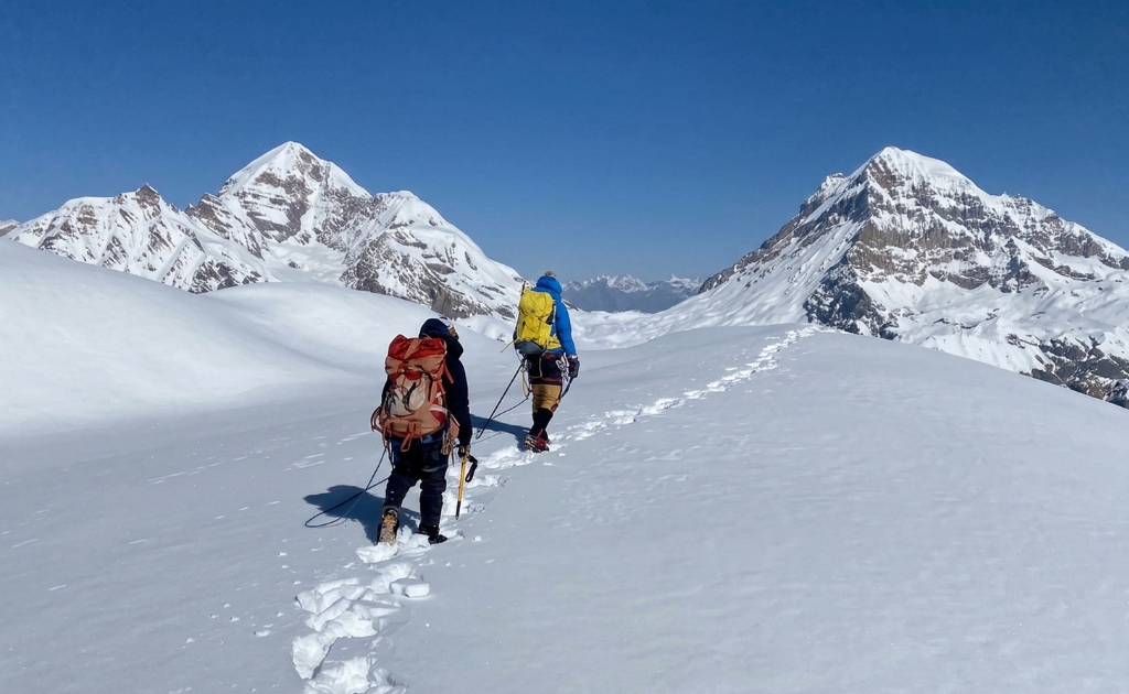 Climbers walking roped together on a snowy ridge during Chulu Far East climb with Annapurna peaks in the background