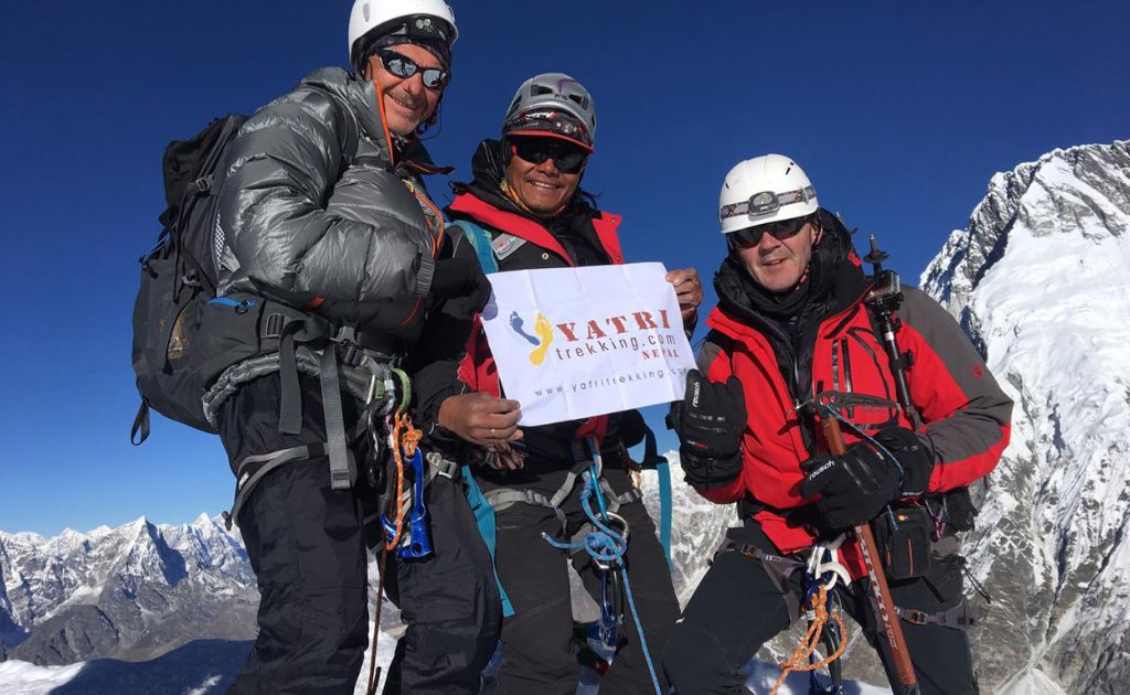 Team of climbers and guides standing at the summit of Island Peak in the Everest region
