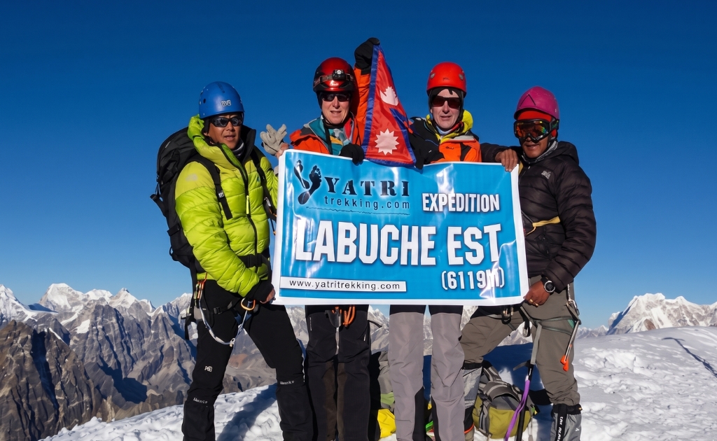 Climbers standing on the summit of Lobuche East with views of Everest Nuptse and surrounding Himalayan peaks