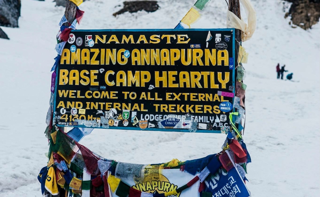 Entrance sign at Annapurna Base Camp (4,130m) surrounded by the Himalayan peaks in Nepal