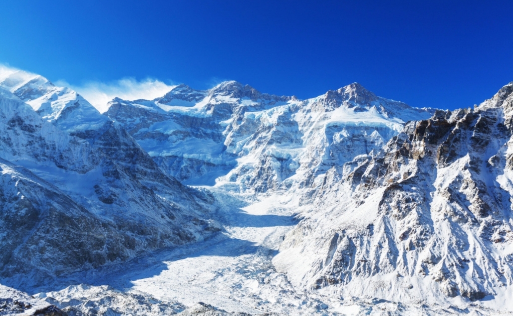 Snow-covered Kanchenjunga mountain peak under clear blue sky in the eastern Himalayas of Nepal