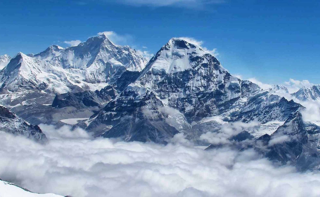 Snow-covered Mount Makalu surrounded by dramatic clouds and rugged Himalayan landscape in Nepal