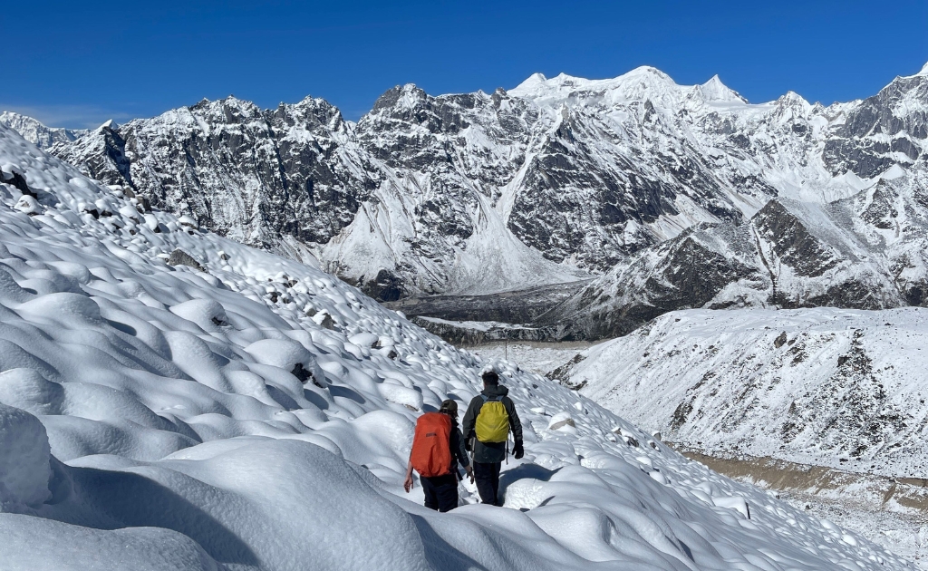 Hikers traversing a snow-covered trail near Samagaun in the Manaslu region