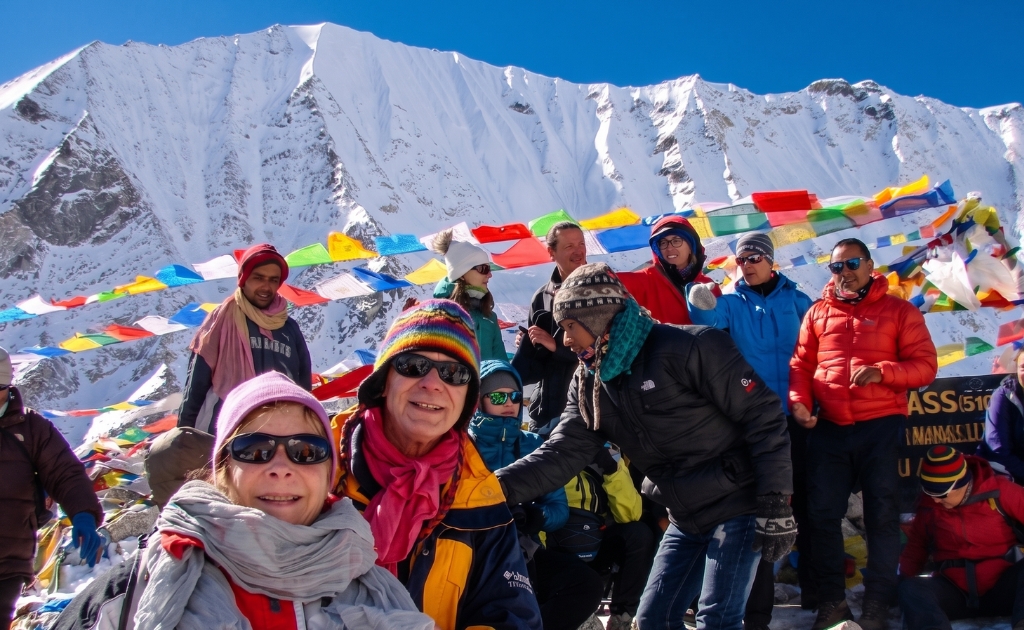 Trekkers crossing Larkya La Pass with snow-covered peaks and high-altitude landscape on the Manaslu Circuit Trek in Nepal