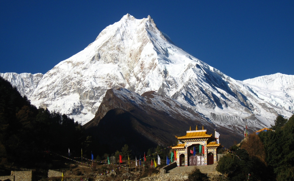 Snow-covered peak of Mount Manaslu rising above the surrounding Himalayan landscape