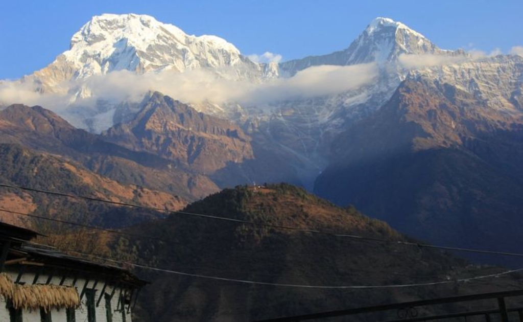 Sunrise view from Ghandruk village with Annapurna South and Hiunchuli peaks glowing above traditional houses
