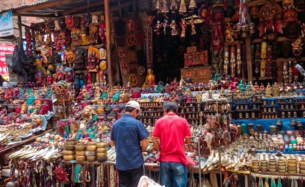 Traditional handicraft market in Thamel, Kathmandu, Nepal, displaying colorful masks, singing bowls, Buddhist statues, handmade jewelry, and local souvenirs.